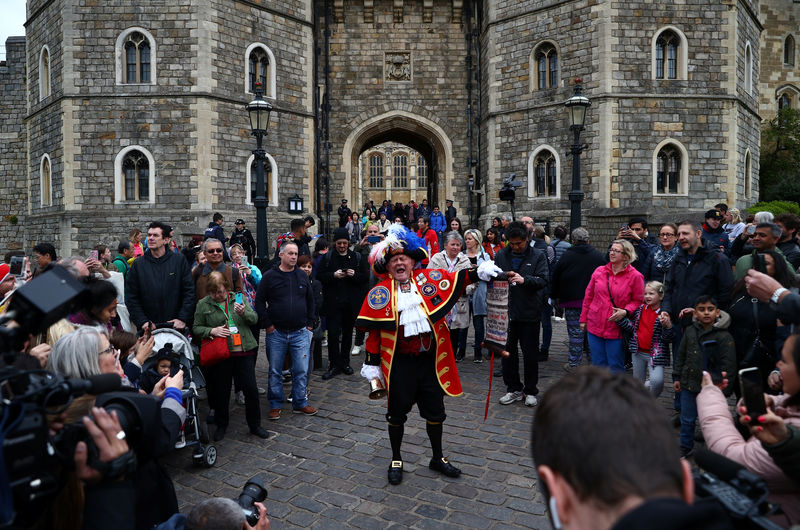 © Reuters. Un hombre vestido con un disfraz anuncia el nacimiento del hijo del príncipe Enrique y Meghan Markle fuera de del Castillo de Windsor en Windsor.