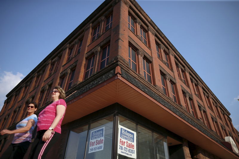 © Reuters. FILE PHOTO: People walk by an unoccupied commercial real estate business for sale in downtown Superior