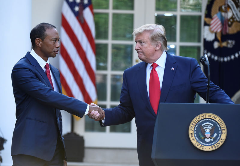 © Reuters. U.S. President Donald Trump greets Tiger Woods before awarding him the Presidential Medal of Freedom at the White House in Washington