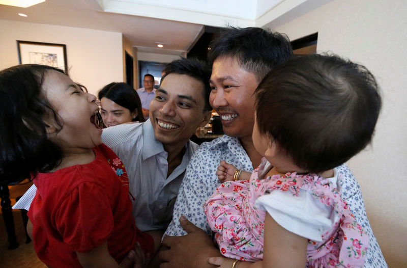 © Reuters. Los reporteros de Reuters Wa Lone y Kyaw Soe Oo celebran con sus hijos su salida de prisión, tras recibir un indulto presidencial en Rangún