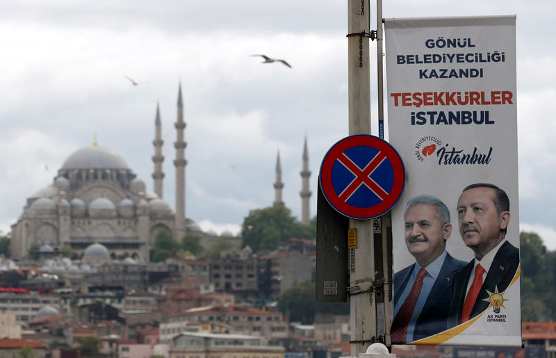 © Reuters. An election banner with the pictures of Turkish President Erdogan and AK Party mayoral candidate Yildirim is seen over the Galata bridge in Istanbul