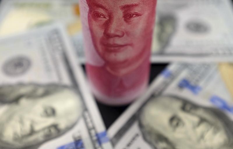 © Reuters. U.S. 100 dollar banknotes and a Chinese 100 yuan banknote are seen in this picture illustration in Beijing, China