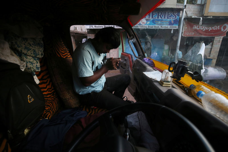 © Reuters. Rajesh Raut prays inside the truck that he currently drives and lives in, at a street in Mumbai