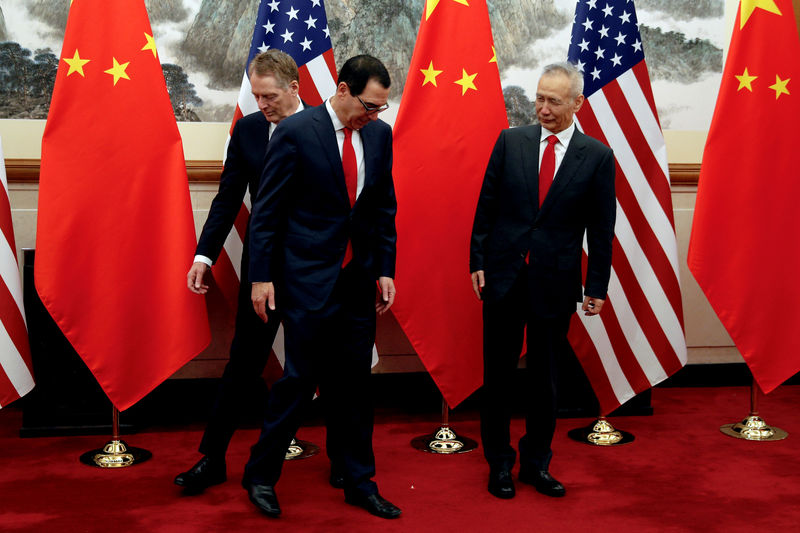 © Reuters. FILE PHOTO: Chinese Vice Premier Liu He looks as U.S. Treasury Secretary Mnuchin swaps places with his Trade Representative Lighthizer during a photograph session in Beijing