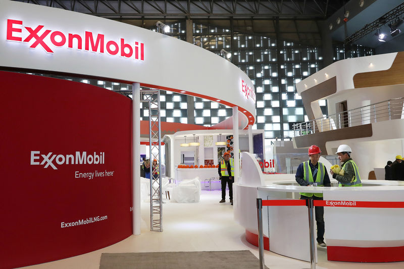 © Reuters. Workers are seen at the booth of ExxonMobil in preparation ahead of the LNG2019 in Shanghai