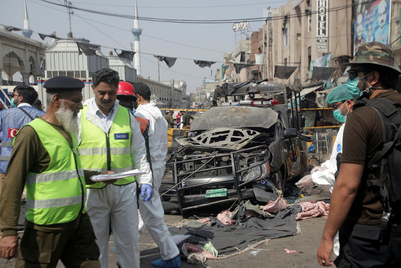 © Reuters. Agentes de segurança vasculham local de explosão em Lahore, no Paquistão