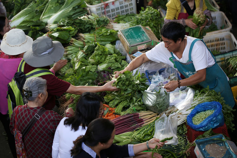 © Reuters. People shop for vegetables at a market in Kunming