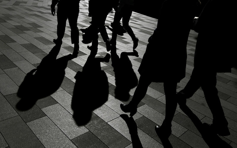 © Reuters. Workers cast shadows as they stroll among the office towers Sydney's Barangaroo business district in Australia's largest city