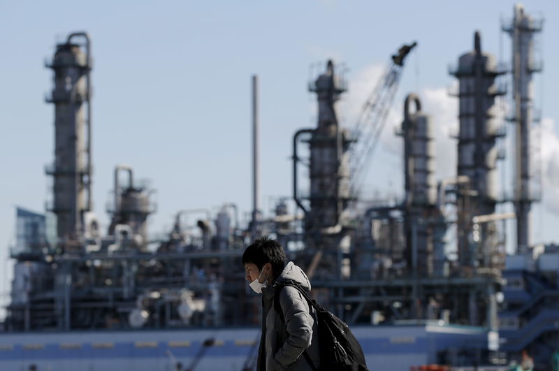 © Reuters. FILE PHOTO: Worker walks near a factory at the Keihin industrial zone in Kawasaki