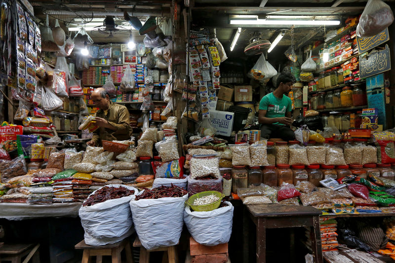 © Reuters. FILE PHOTO: Vendors wait for customers at their respective shops at a retail market in Kolkata