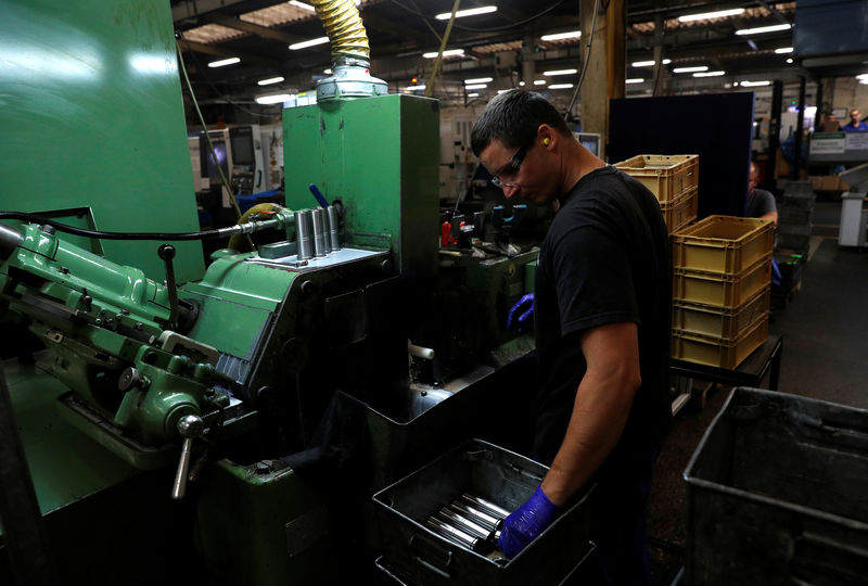 © Reuters. A worker holds a component for a Volvo truck at the Muller manufacturing facility in Redditch