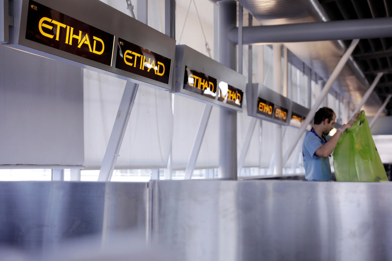 © Reuters. FILE PHOTO: A worker cleans behind Etihad airlines counters at JFK International Airport in New York