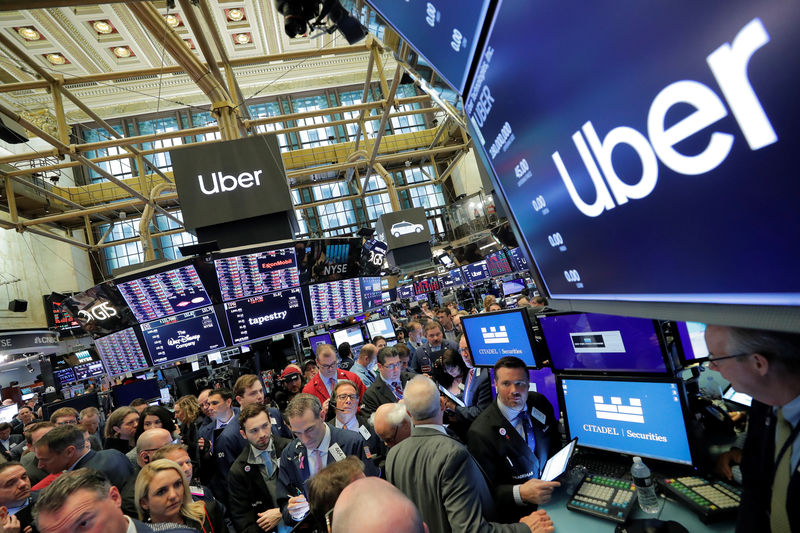 © Reuters. Traders gather at post where Uber Technologies Inc. holds IPO on floor of NYSE in New York