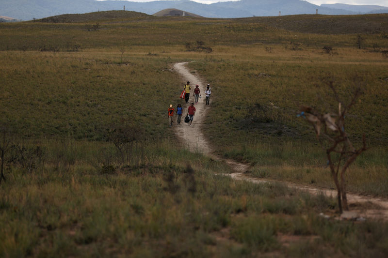 © Reuters. Venezuelans walk along a trail into Brazil at the border city of Pacaraima