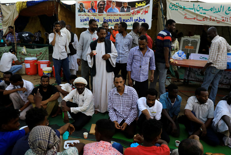 © Reuters. في رمضان.. المحتجون يتناولون إفطارهم في اعتصام الخرطوم