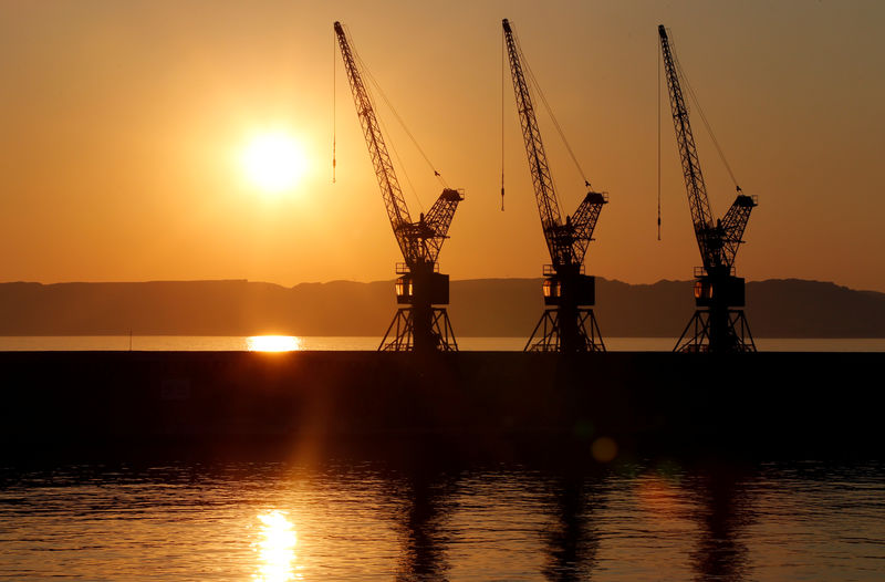 © Reuters. FILE PHOTO: The sun sets behind loading cranes in the old harbour of Marseille