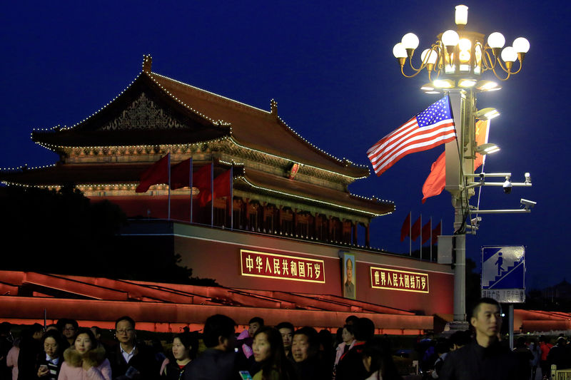 © Reuters. People walk under U.S. and China's flags at the Forbidden City during the visit by U.S. President Donald Trump in Beijing