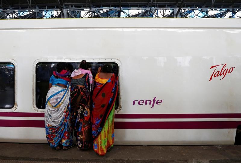 © Reuters. En la imagen, mujeres miran el interior de un tren Talgo en una estación en Mumbai