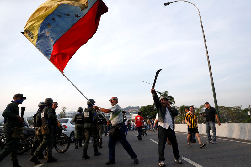 © Reuters. Simpatizante da oposição na Venezuela balança bandeira do país perto de base aérea de 