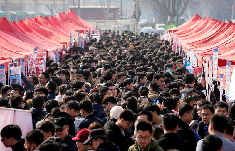 © Reuters. FILE PHOTO: Job seekers crowd a job fair at Liberation Square in Shijiazhuang