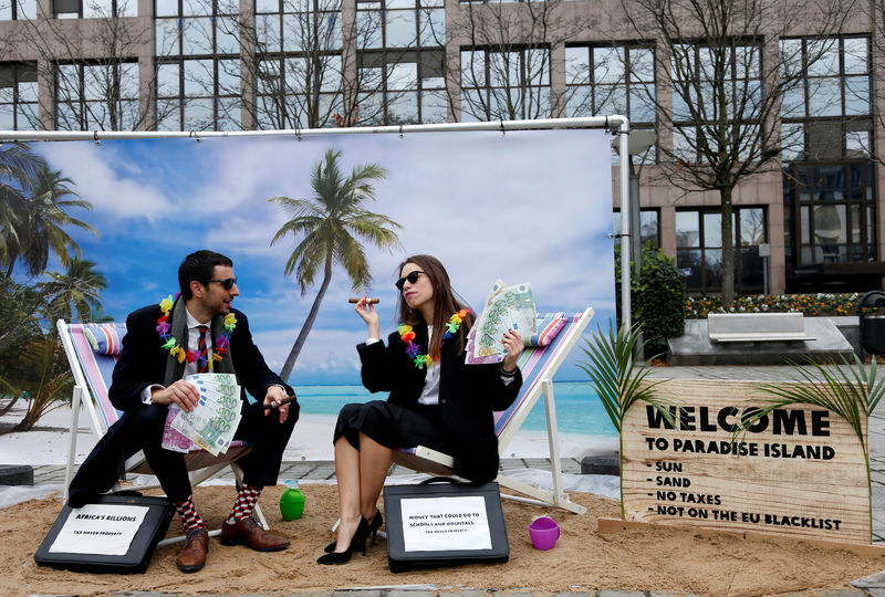 © Reuters. FILE PHOTO: Activists stage a protest on a mock tropical island beach representing a tax haven outside a meeting of European Union finance ministers in Brussels