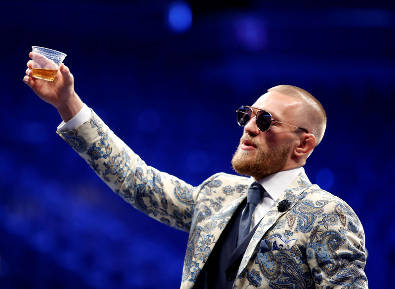 © Reuters. FILE PHOTO: UFC lightweight champion Conor McGregor of Ireland raises a cup of Irish whiskey during post-fight news conference at T-Mobile Arena in Las Vegas