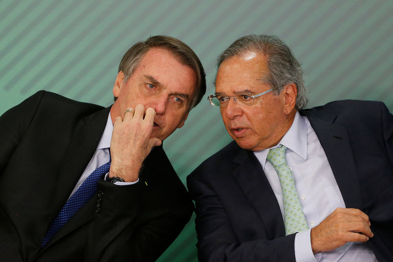 © Reuters. Presidente Jair Bolsonaro conversa com ministro da Economia, Paulo Guedes, durante cerimônia no Palácio do Planalto