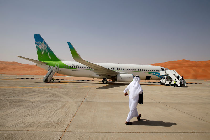 © Reuters. FILE PHOTO: An Aramco employee walks towards an Aramco private plane at the airport at Shaybah oilfield in the Empty Quarter