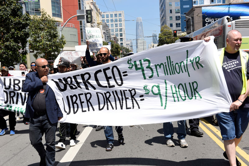 © Reuters. FILE PHOTO: Protestors march through the financial district, demanding fair wages and more transparency during a strike against Uber in San Francisco
