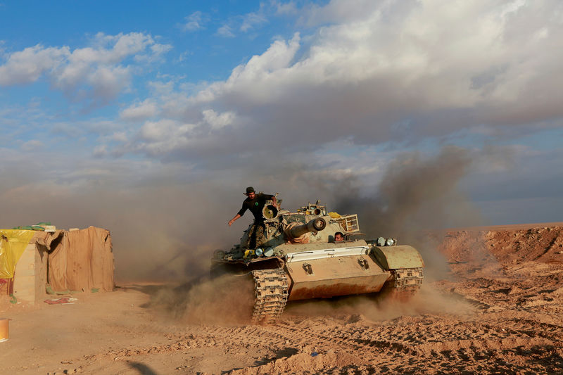 © Reuters. FILE PHOTO: PMF fighters ride in a tank near the Iraqi-Syrian border in al-Qaim, Iraq.