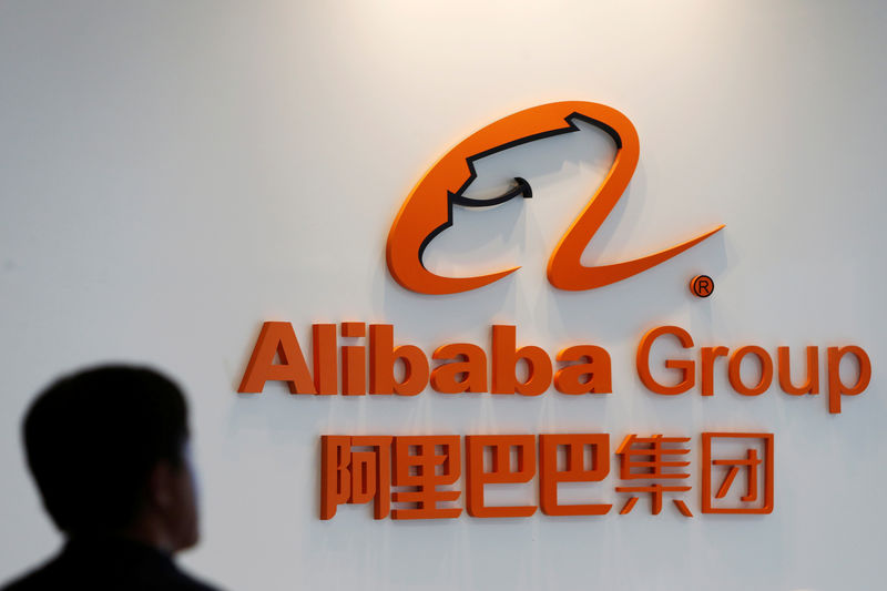 © Reuters. A man stands near the logo of Alibaba Group at the company's newly-launched office in Kuala Lumpur