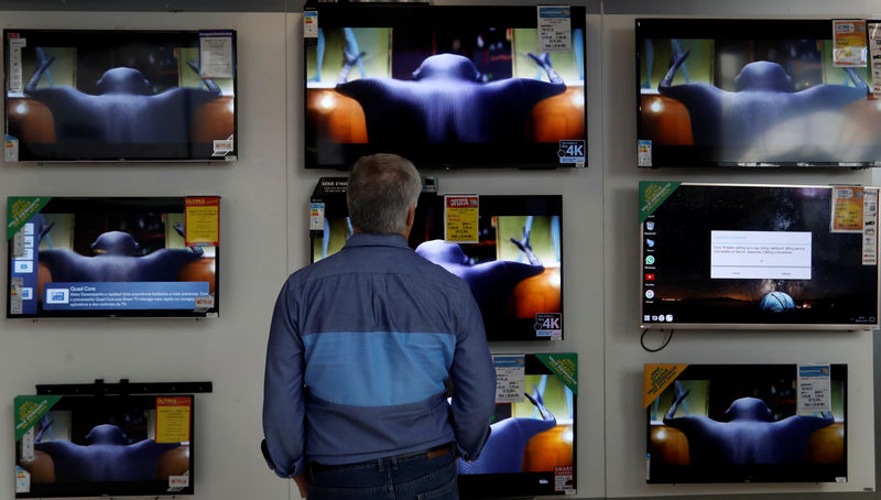 © Reuters. Homem checa preços de TVs em loja em São Paulo