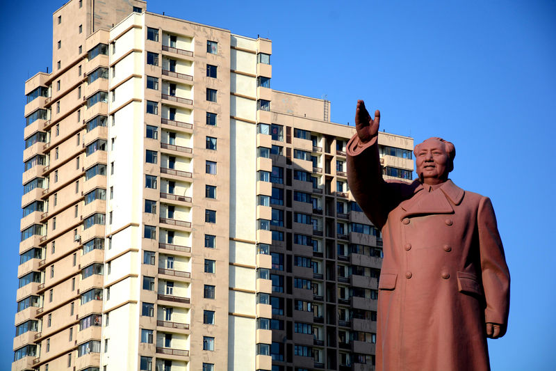 © Reuters. FILE PHOTO: Statue of former Chinese chairman Mao Zedong is seen in front of a residential building in Dandong New Zone
