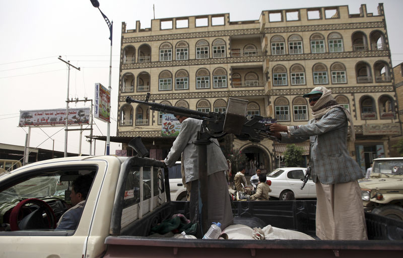 © Reuters. Followers of Yemen's al-Houthi Shi'ite group ride in an open vehicle while carrying weapons to secure a road in Saada