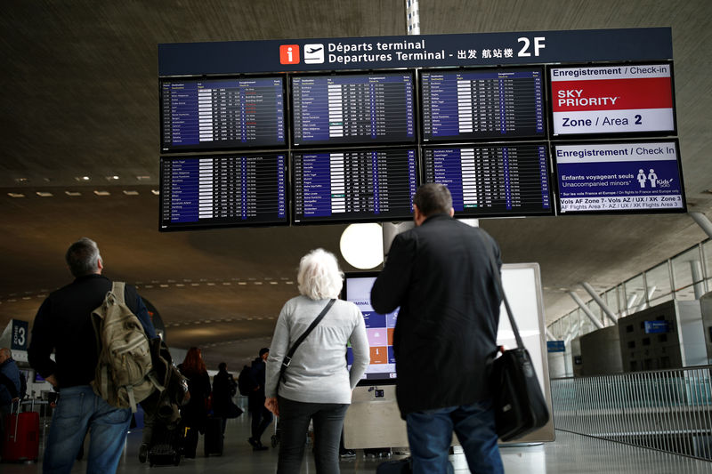 © Reuters. Travellers look at a flight departure information board at Charles de Gaulle airport, operated by Aeroports de Paris, in Roissy