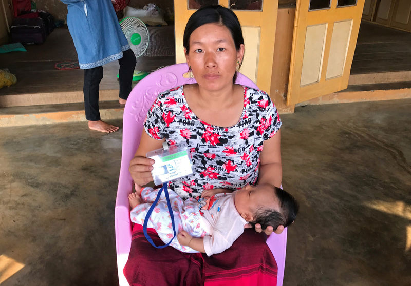 © Reuters. The wife of Lamung Brang Aung poses for a photo with their child in Hpakant