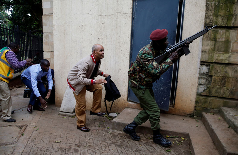 © Reuters. FILE PHOTO: Member of security forces keeps guard as people are evacuated at the scene where explosions and gunshots were heard at the Dusit hotel compound, in Nairobi