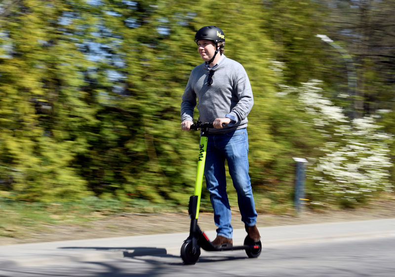 © Reuters. A man rides an e-scooter during a presentation at the DESY campus in Hamburg