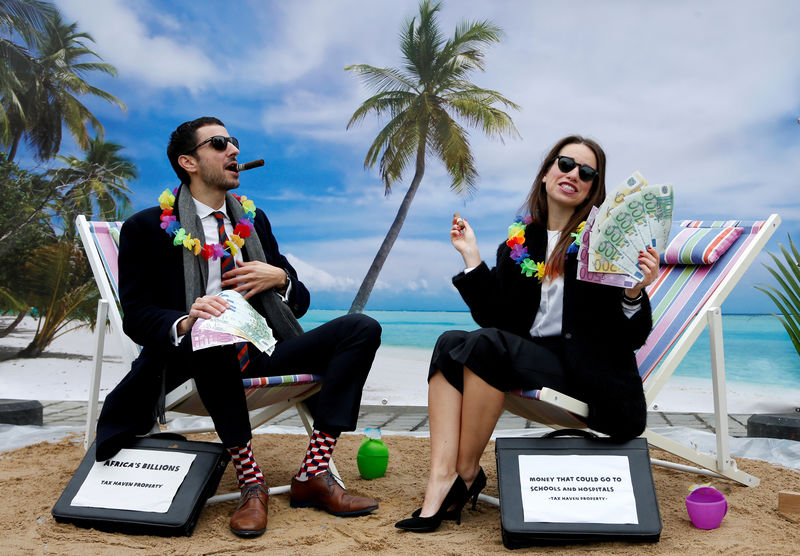 © Reuters. FILE PHOTO: Activists stage a protest on a mock tropical island beach representing a tax haven outside a meeting of European Union finance ministers in Brussels