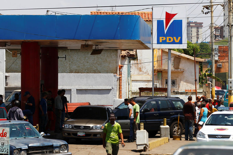 © Reuters. People with vehicles wait in line to attempt to refuel at a gas station of the state oil company PDVSA in Maracaibo
