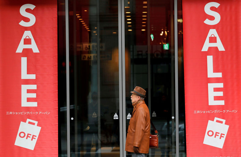 © Reuters. FILE PHOTO: Man stands in front of shopping mall nearby Bank of Japan building in Tokyo