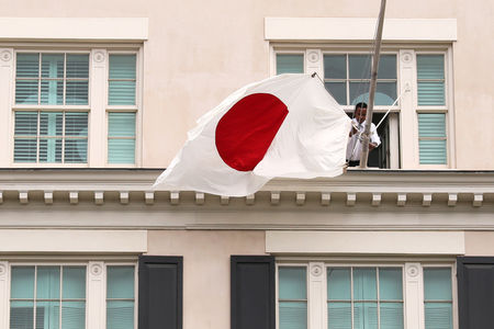 © Reuters. In anticipation of a visit by Japan's Prime Minister Abe, workers unfurl a Japanese flag at the Blair House in Washington