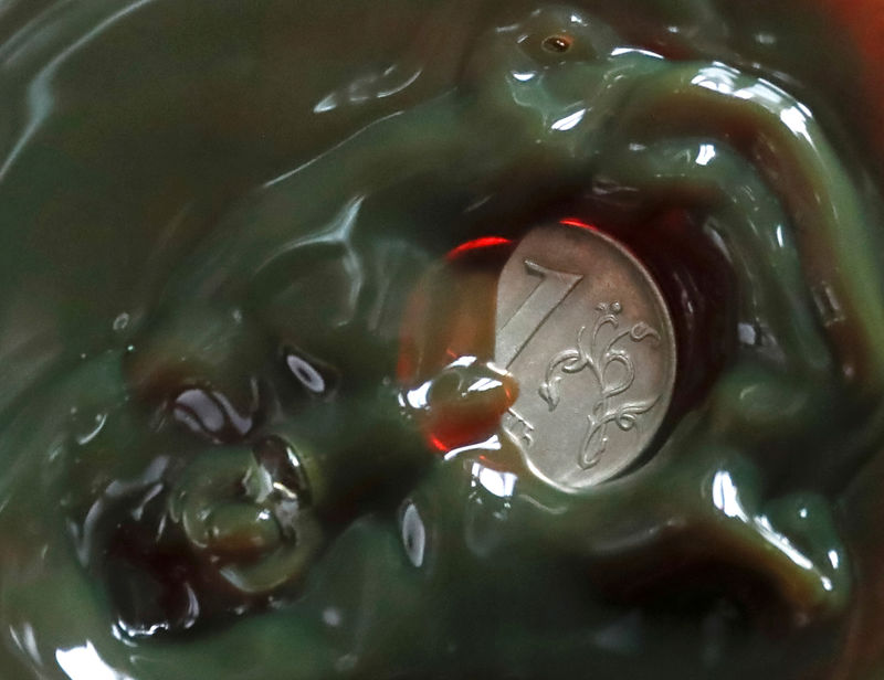 © Reuters. FILE PHOTO: A view shows a one Russian rouble coin inside a bulb with crude oil at a laboratory in the Irkutsk Oil Company-owned Yarakta Oil Field in Irkutsk Region