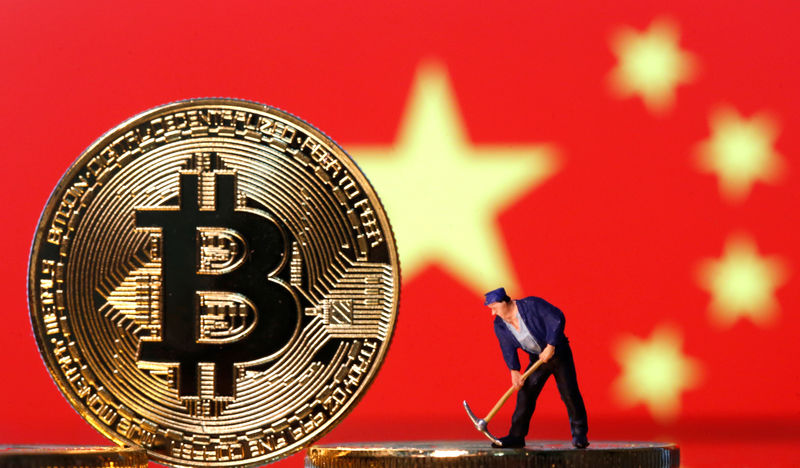 © Reuters. Picture illustration of a small toy figurine and representations of the Bitcoin virtual currency displayed in front of an image of China's flag