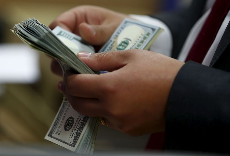 © Reuters. FILE PHOTO: An employee counts U.S. dollar notes in a bank in Cairo