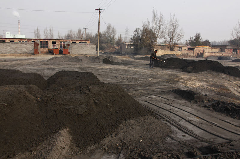 © Reuters. A villager shovels cast-off tailings of crushed mineral ore that contain rare earth metals in Xinguang Village, located on the outskirts of the city of Baotou in China's Inner Mongolia Autonomous Region