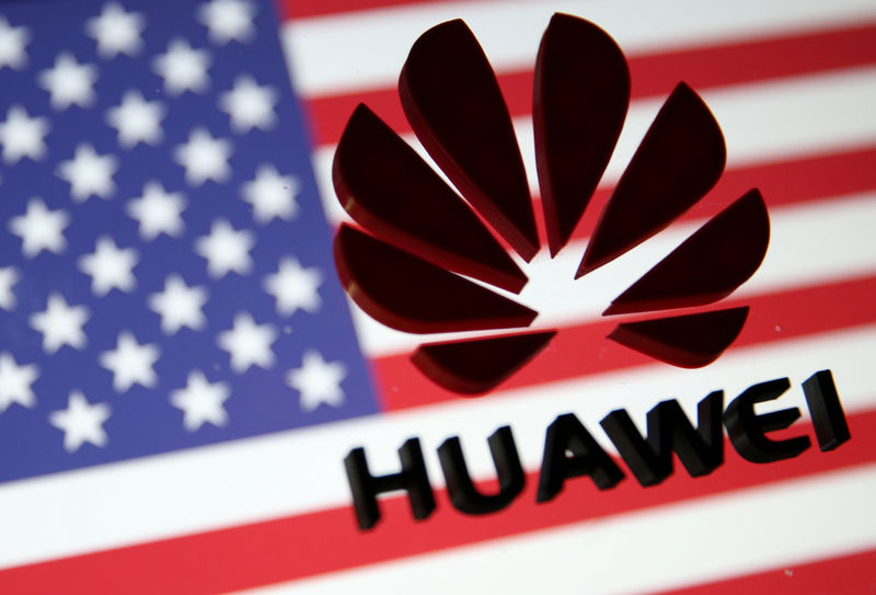 © Reuters. Foto de archivo. La bandera estadounidense tras el logo de Huawei.