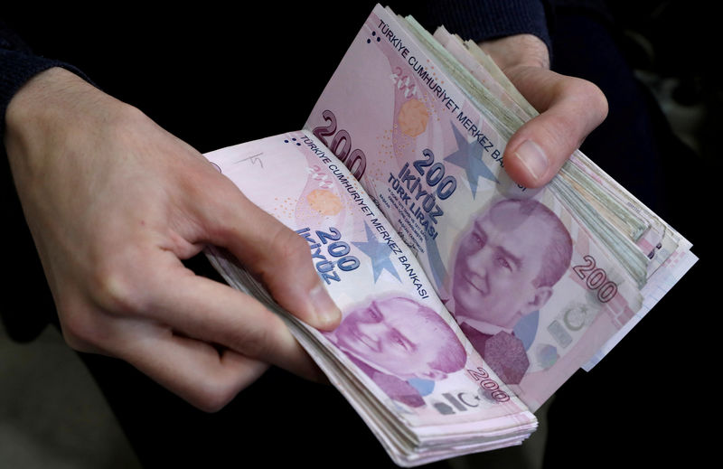 © Reuters. FILE PHOTO: A merchant counts Turkish lira banknotes at the Grand Bazaar in Istanbul