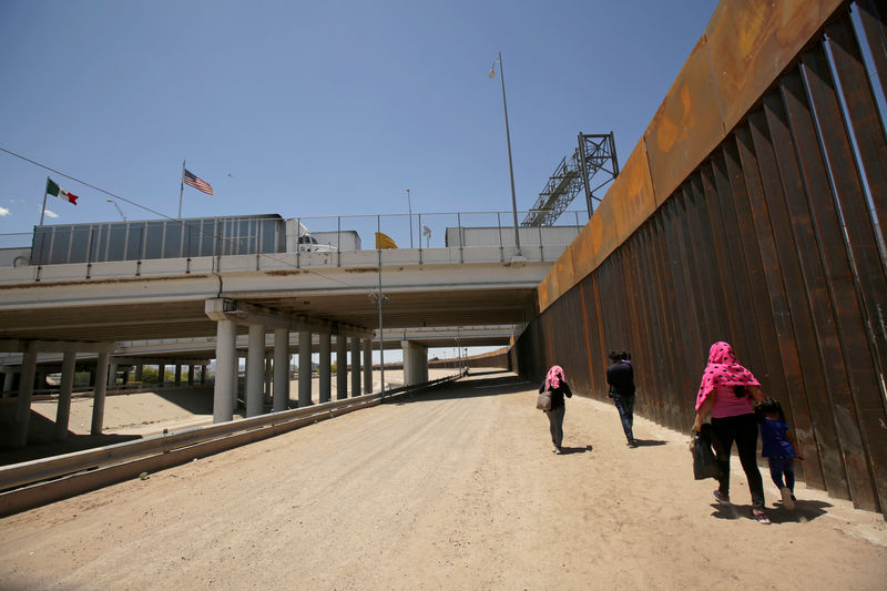 © Reuters. FILE PHOTO: A group of Central American migrants walk next to the U.S.-Mexico border fence after they crossed the borderline in El Paso