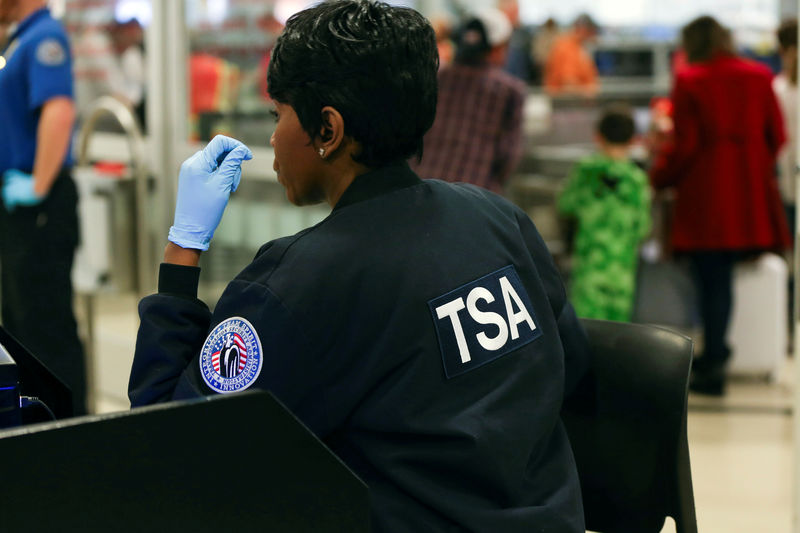 © Reuters. FILE PHOTO - A TSA agent screens passengers at a security checkpoint at Hartsfield-Jackson Atlanta International Airport amid the partial federal government shutdown, in Atlanta